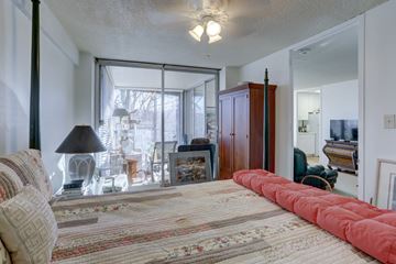 Boulder apartment for rent - a bedroom with a large bed and a living room with a tv