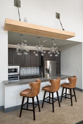 Columbus apartment for rent - A kitchen with a bar area and three brown chairs.