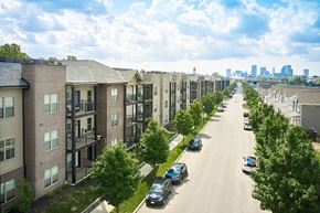 Columbus apartment for rent - A long street with cars parked on the side and apartment buildings on both sides.