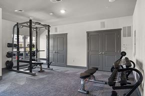 Columbus apartment for rent - A home gym with a squat rack, bench, and weights.