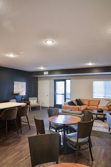 Otsego apartment for rent - A living room with a brown sofa and a white table.