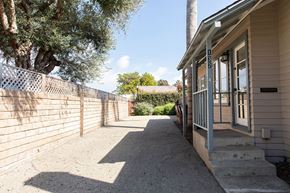 Ventura apartment for rent - A house with a grey door and a concrete pathway leading to it.