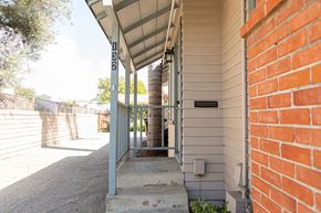 Ventura apartment for rent - A white house with a brick wall and a porch.