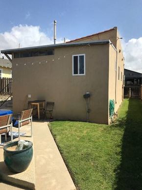 Ventura apartment for rent - A tan house with a green pot in front.