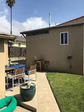 Ventura apartment for rent - A patio with a table and chairs is surrounded by a green hose.