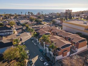 Ventura condo for rent - A sunny day in a residential area with houses and parked cars.