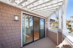 Ventura apartment for rent - A patio with a white pergola and a glass door.
