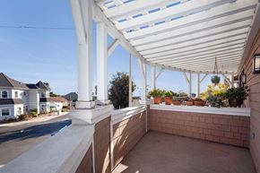 Ventura apartment for rent - A patio with a white roof and pillars with plants on the windowsill.