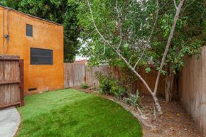 Los Angeles apartment for rent - A backyard with a green lawn and a brown fence.