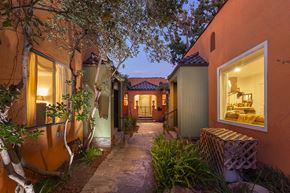 Los Angeles apartment for rent - A narrow alley with a tree in the foreground and a building with a lit window on the right.