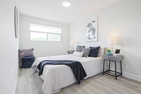 Oshawa apartment for rent - A bedroom with a large bed and a window.