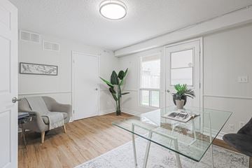 Oshawa apartment for rent - A living room with a glass table and a grey couch.