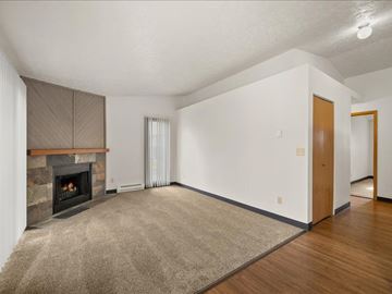 Spokane Valley apartment for rent - A living room with a fireplace and a rug on the floor.