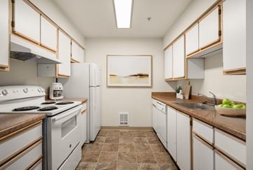 Spokane apartment for rent - A kitchen with white cabinets and brown countertops.