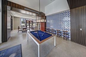 Coral Gables apartment for rent - a pool table in the lobby of a hotel with tables and chairs