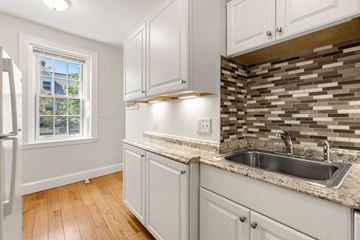 Cambridge apartment for rent - A kitchen with white cabinets and a granite countertop.