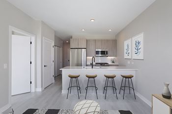 A kitchen with a large island with four stools in front of it