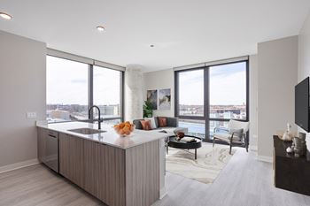 A kitchen with an island and a living room with a couch and a tv