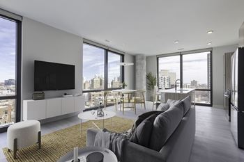 A living room with a gray couch and a yellow rug