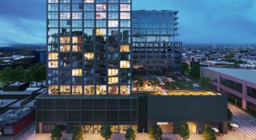 Chicago apartment for rent - A modern glass building with a black building in front of it.