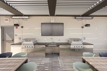 Outdoor cooking area with two high end grills and large tv