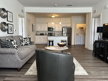 Mechanicsburg apartment for rent - A modern living room with a grey couch and a black leather chair.