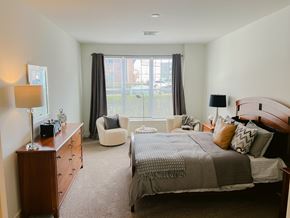 Mechanicsburg apartment for rent - A bedroom with a large bed and a chair.