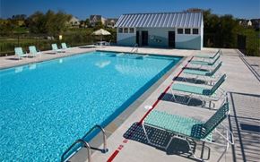 Mount Joy apartment for rent - A large outdoor swimming pool with lounge chairs and a building in the background.