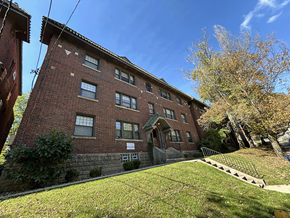 Pittsburgh apartment for rent - a red brick apartment building with a green lawn and a blue sky