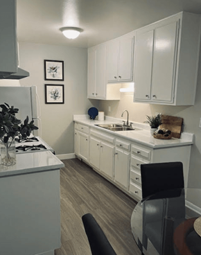 Riverside apartment for rent - A kitchen with white cabinets and a black chair.