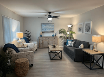 Riverside apartment for rent - A living room with a ceiling fan and a painting on the wall.