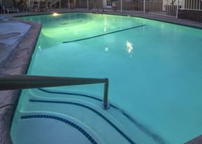 Riverside apartment for rent - a large pool with a fence around it and a light shining on the water