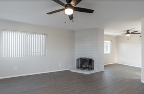 Riverside apartment for rent - A room with a fireplace and a ceiling fan.