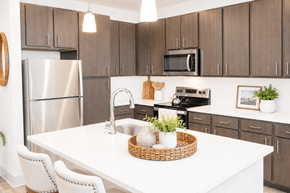 Gulf Breeze apartment for rent - A kitchen with a white table and brown cabinets.