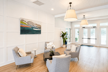 Gulf Breeze apartment for rent - A living room with a grey couch and a painting on the wall.