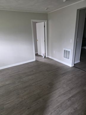 Burrillville apartment for rent - A room with a white door and wood flooring.