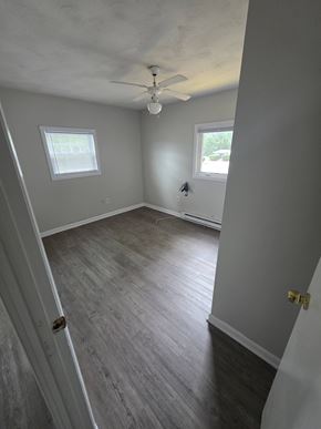 Burrillville apartment for rent - A room with a ceiling fan and two windows.