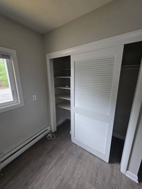 Burrillville apartment for rent - A room with a white closet and a window.