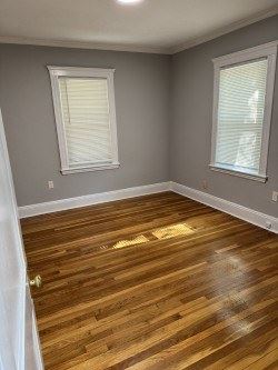 Jamaica Plain apartment for rent - A room with wooden floors and two windows.