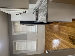 Jamaica Plain apartment for rent - A kitchen with a stainless steel range hood and wooden flooring.