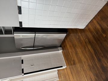 Jamaica Plain apartment for rent - A kitchen with a stainless steel dishwasher and a white tiled floor.