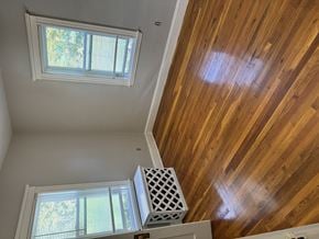 Jamaica Plain apartment for rent - A white air vent is on the floor next to a window.