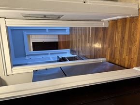 Jamaica Plain apartment for rent - A white fridge with a blue door and a wooden wall.