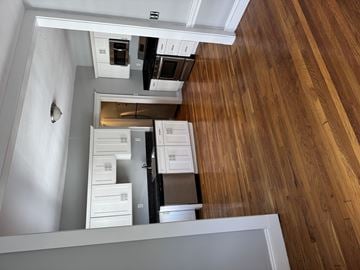 Jamaica Plain apartment for rent - A kitchen with wooden floors and white cabinets.
