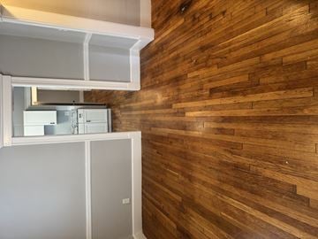 Roslindale apartment for rent - A white refrigerator is in a kitchen with a wooden wall.