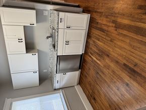 Roslindale apartment for rent - A kitchen with white cabinets and a wooden wall.