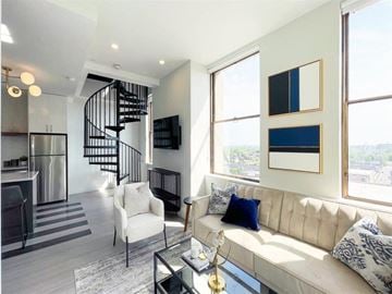 Detroit apartment for rent - a living room with a couch and a spiral staircase