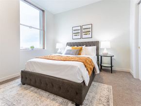 Detroit apartment for rent - a bedroom with a bed and a large window