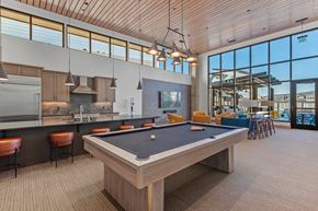 Spokane Valley apartment for rent - A pool table in a clubhouse with a kitchen and bar