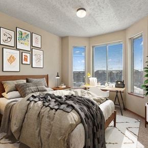 Cheney apartment for rent - a bedroom with a bed and three windows